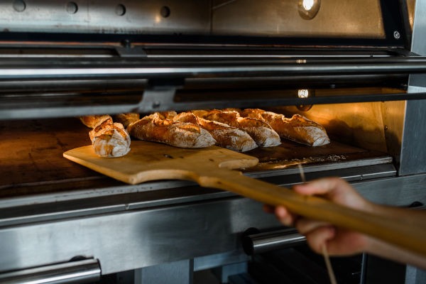 artisan boulanger qui enfourne ses baguettes